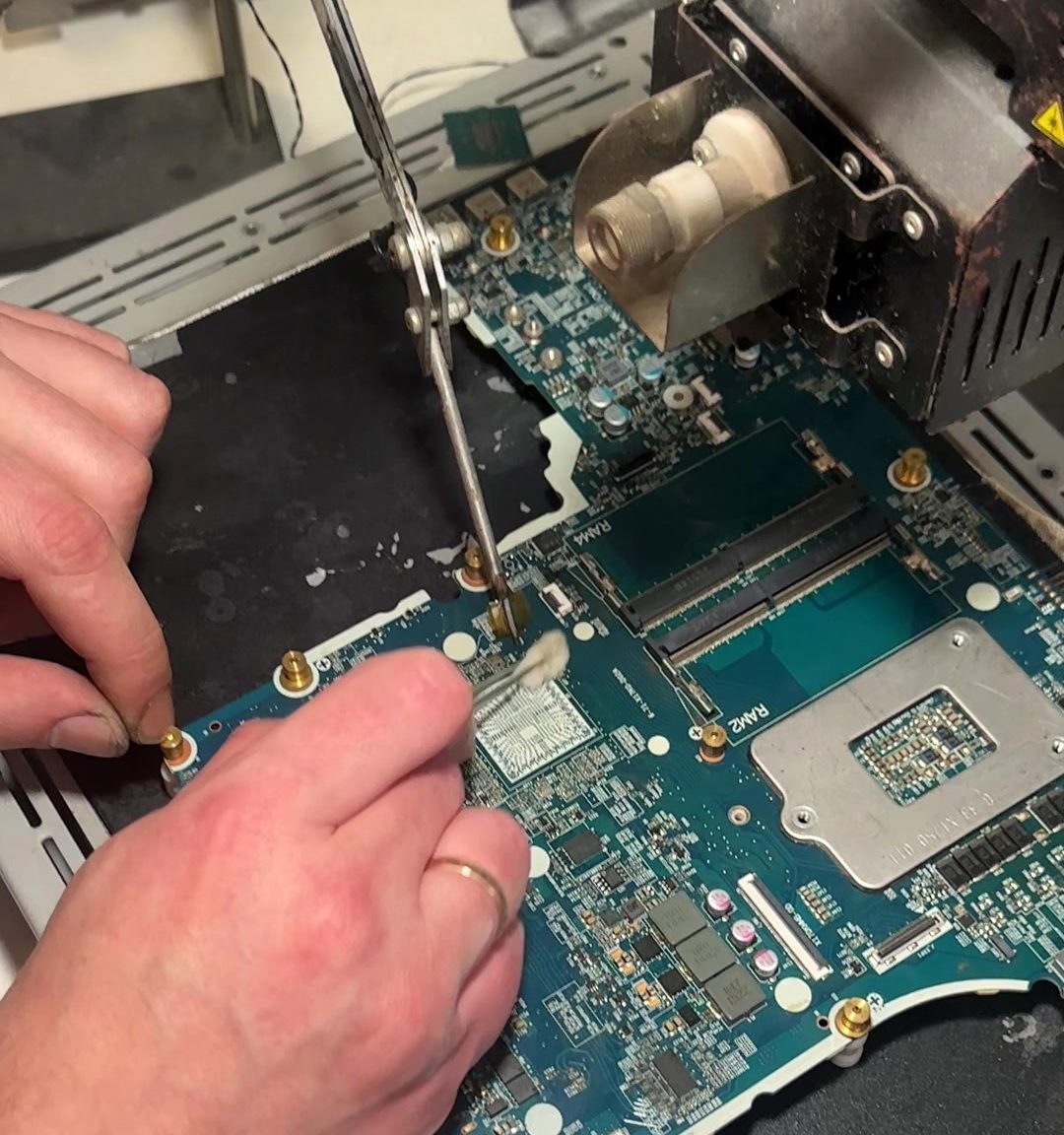 A laptop board clamped for rework